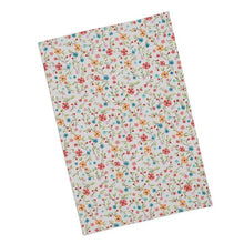 ivory colored dishtowel with multi-colored flowers daisies covering the towel from front to back