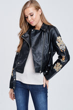 faux leather jacket with embroidered sleeves. meets at your waist. zip up in front and tie around waist