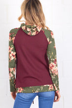 back view of burgundy and olive floral sweater top. Long sleeve with olive floral contrast from burgundy flows to draw string gathered neck line and front pouch
