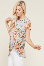 side view of greyish lavender shortsleeve top with floral print and a twist hem at the bottom