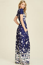 side view of Navy ombre floral short sleeve long maxi dress with white floreal print heavy on top and bottom and faded in middle like falling flowers. scoopneck and pockets