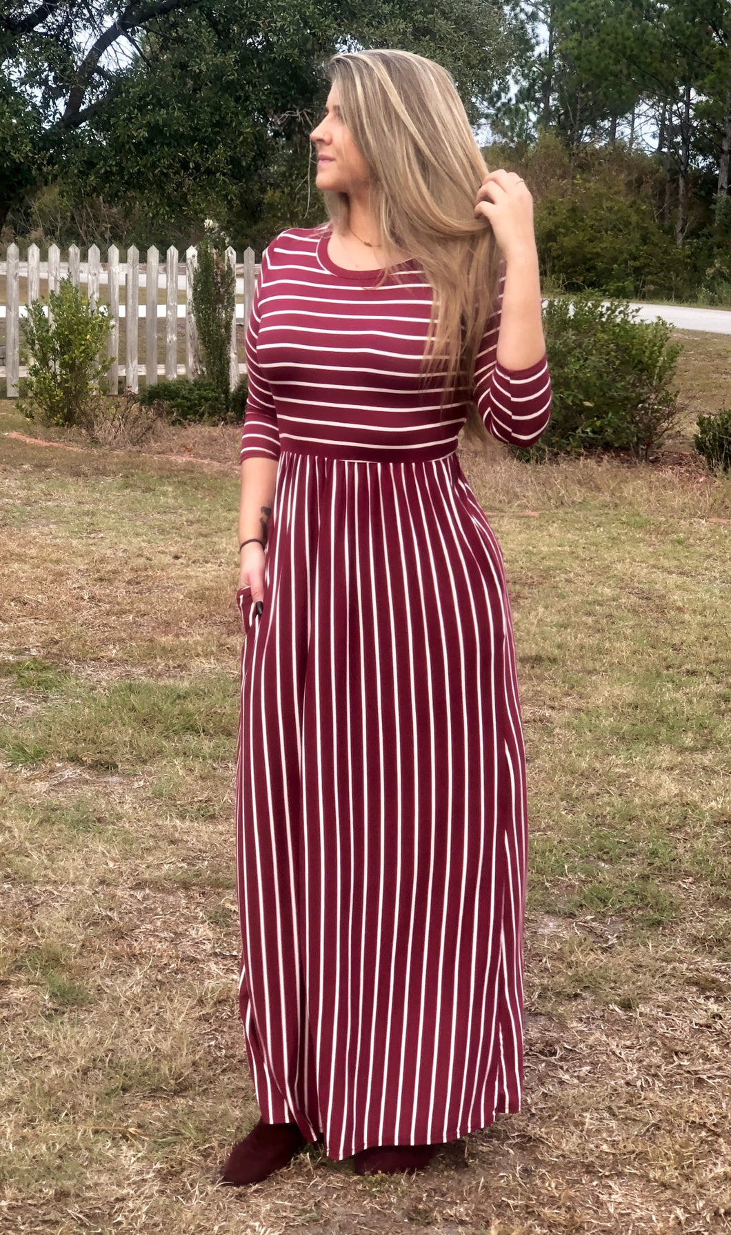 full body view of 3/4 quarter sleeve burgundy and white two directional stripes long maxi dress. cinches at the small of the waist. perfect for shorter and taller people with its stretchy and soft material