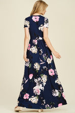 back view of Navy and floral print short sleeve long maxi with soft and stretchy material, scoopneck, and pockets
