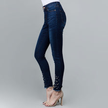 side view of dark wash skinny jeans with embellished pearls on shin down to frayed hem