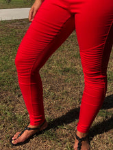 up close view of vibrant bright red moto jeggings with real back pockets and an elastic waistband. can be worn everyday casual or with a dressy top and heels. S/M fit- 2-6. M/L fit- 8-10