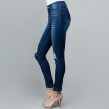 side view of pearl distressed jeans. blue jeans with distressed knees lined with pearls. for that comfy and classy look