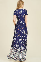 back view of Navy ombre floral short sleeve long maxi dress with white floreal print heavy on top and bottom and faded in middle like falling flowers. scoopneck and pockets