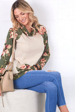 cream and olive floral sweater top. Long sleeve with olive floral contrast from burgundy flows to draw string gathered neck line and front pouch