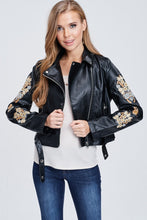 faux leather jacket with embroidered sleeves. meets at your waist. zip up in front and tie around waist
