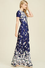 side view of Navy ombre floral short sleeve long maxi dress with white floreal print heavy on top and bottom and faded in middle like falling flowers. scoopneck and pockets