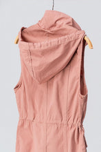 back view of blush sleeveless collared cargo vest with 4 front pockets, draw string at waist, and hood