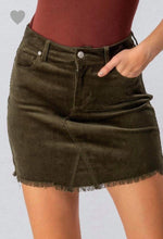 olive green colored corduroy mini skirt with a zipper fly. equipped with belt loops and pockets. frayed hem on the bottom