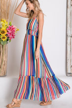 side view of mulit-color stripe serape maxi with adjustable spaghetti strapes, smocked waist, and ruffle hem