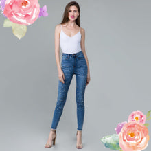 blue high rise skinny jeans with stretch. fully embellished in silver and white pearls down to fray hem detail